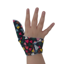 Load image into Gallery viewer, Hearts on a dark background-themed thumb guard to help stop thumb sucking and other habits. Has a moisture resistant lining. The Thumb Guard Store.

