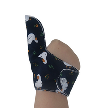 Load image into Gallery viewer, Hand showing thumb pouch of a White ducks on a dark background-themed thumb guard to help stop thumb sucking and other habits. Has a moisture resistant lining. The Thumb Guard Store.
