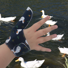 Load image into Gallery viewer, Image shows a White ducks on a dark background-themed thumb guard to help stop thumb sucking and other habits. Has a moisture resistant lining. The Thumb Guard Store.
