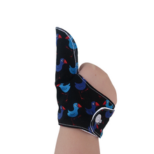 Load image into Gallery viewer, A fabric thumb guard to help break habits such as thumb sucking, nail biting and skin picking, in a Pukeko-themed fabric. The image shows a thumb guard on a child&#39;s hand. The guard has a moisture-resistant lining.   Made by the Thumb Guard Store.
