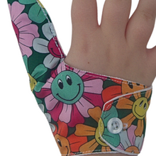 Load image into Gallery viewer, A fabric thumb guard made by The Thumb Guard Store, designed to help children and adults stop habits such as thumb sucking and skin picking. The guard in the image has a smiling flower-themed outer fabric and button fastening
