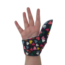 Load image into Gallery viewer, Hearts on a dark background-themed thumb guard to help stop thumb sucking and other habits. Has a moisture resistant lining. The Thumb Guard Store.
