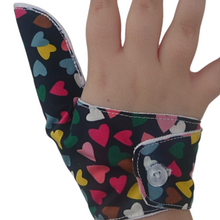 Load image into Gallery viewer, Image shows button fastening on a Hearts on a dark background-themed thumb guard to help stop thumb sucking and other habits. Has a moisture resistant lining. The Thumb Guard Store.
