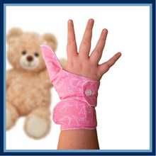 Load image into Gallery viewer, Pink coloured cuffed thumb guard with a dinosaur design. Moisture resistant lining, to help stop thumb sucking. Made by The Thumb Guard Store.
