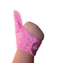 Load image into Gallery viewer, Pink coloured thumb guard with a dinosaur design. Moisture resistant lining, to help stop thumb sucking. Made by The Thumb Guard Store.
