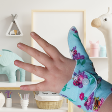 Load image into Gallery viewer, blue coloured cuffed thumb guard with a bugs and bees floral design. Moisture resistant lining, to help stop thumb sucking. Made by The Thumb Guard Store
