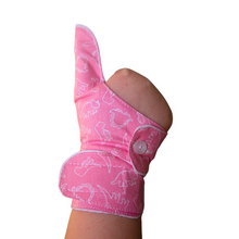 Load image into Gallery viewer, Pink coloured cuffed thumb guard with a dinosaur design. Moisture resistant lining, to help stop thumb sucking. Made by The Thumb Guard Store.
