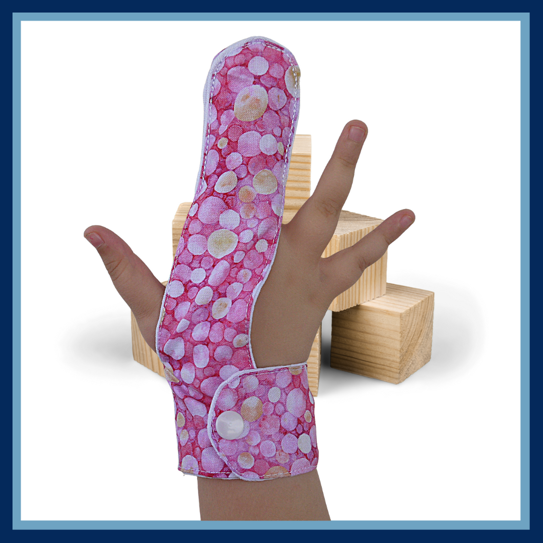 A finger guard to help children stop finger-sucking and other habits. Guard has a moisture-resistant lining. The outer fabric features a pink and lemon bubble design design.  A choice of fastenings is available. The Thumb Guard Store