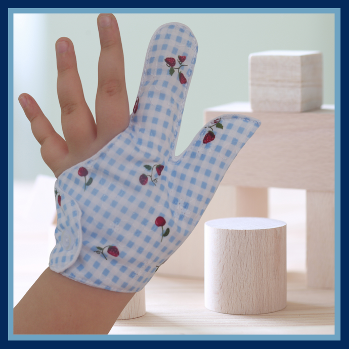 Prevent thumb sucking with this blue check, fruit themed, fabric thumb and finger guard. Features strawberry and cherry design, moisture-resistant lining, and various fastening options. Say goodbye to the habit with comfort and style.